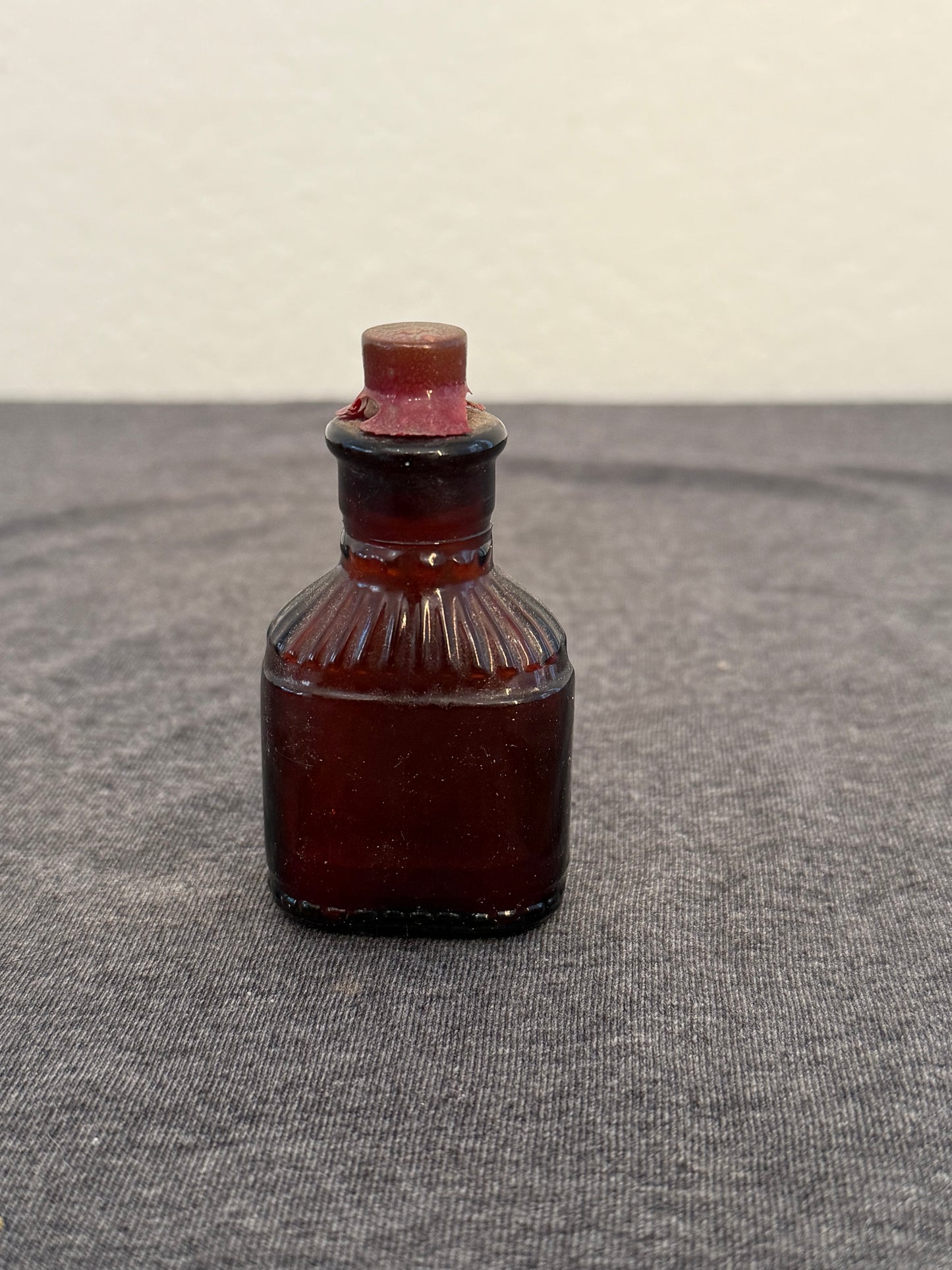 Small brown poison bottle on a textured gray surface