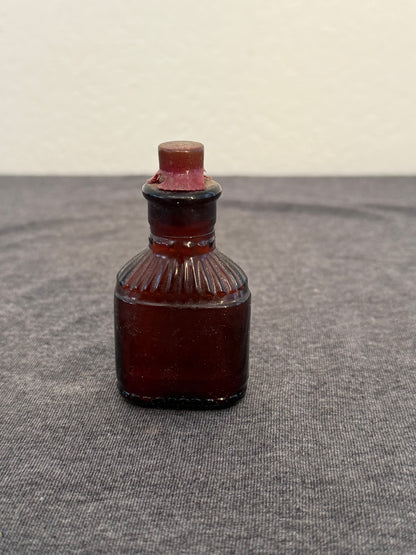 Small brown poison bottle on a textured gray surface