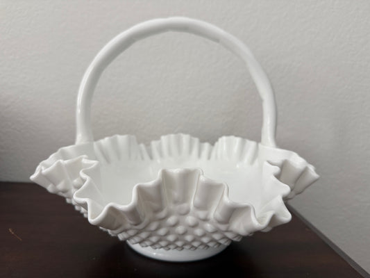 White textured basket on a dark surface with a light gray background