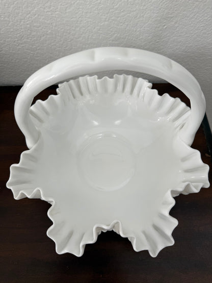 White ceramic basket with decorative rim on a dark surface