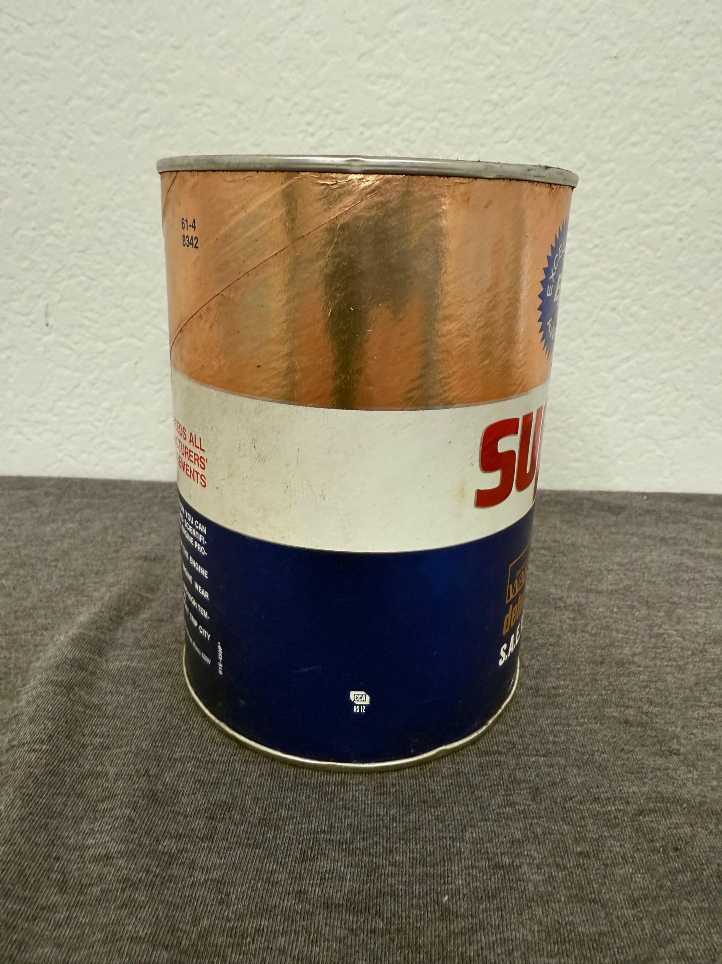 Oil can with a blue label on a textured surface