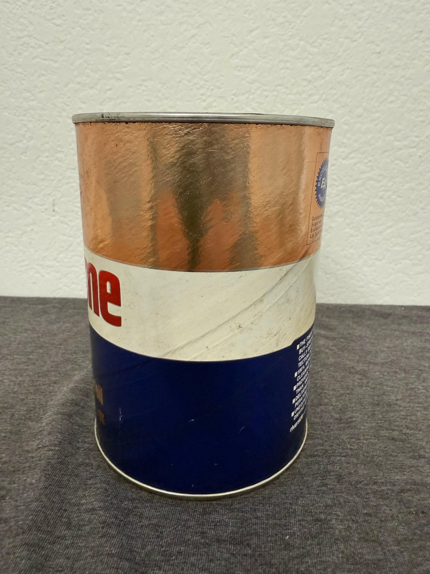 Blue and brown canister on a gray surface with a white background