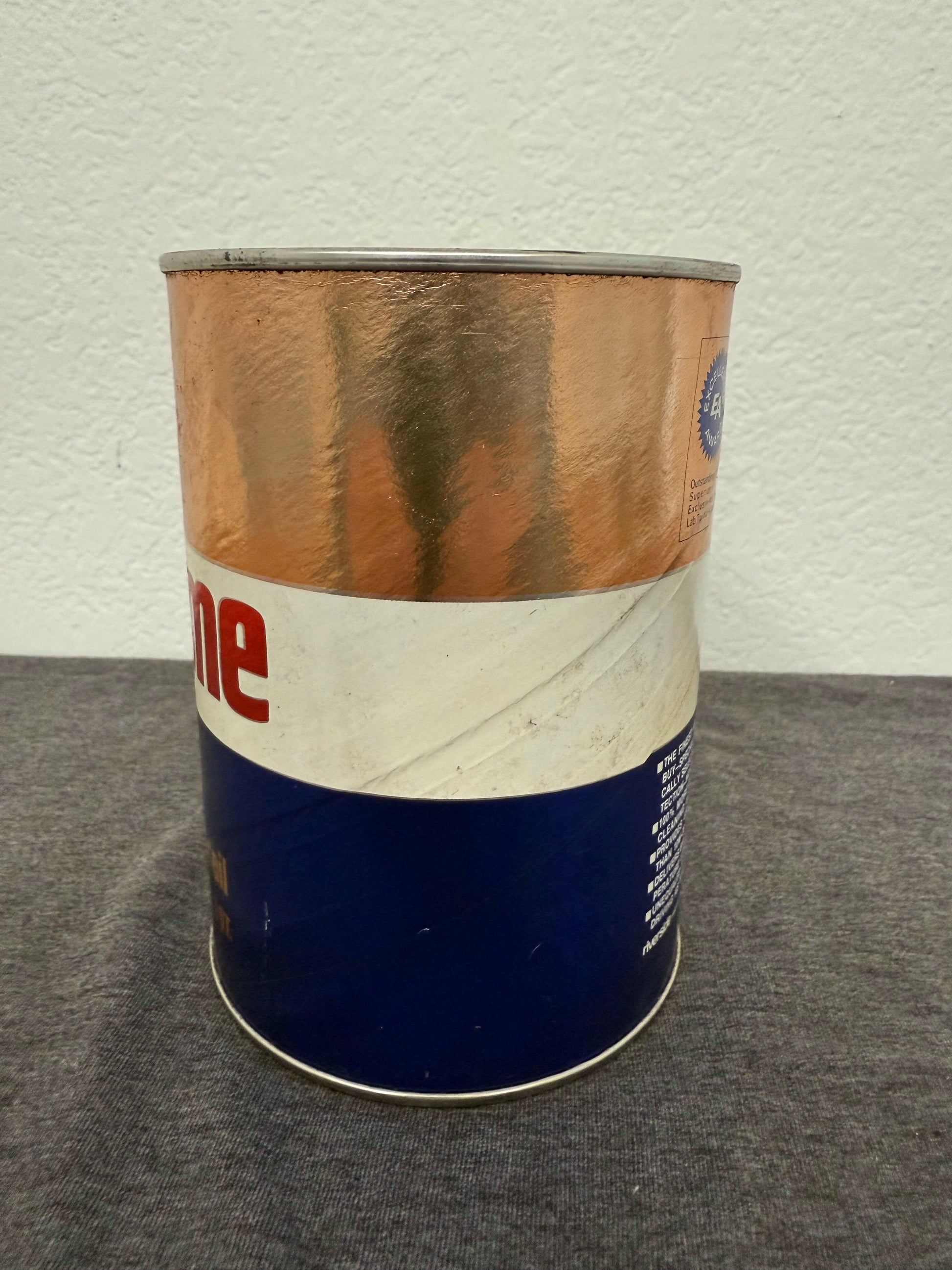 Blue and brown canister on a gray surface with a white background