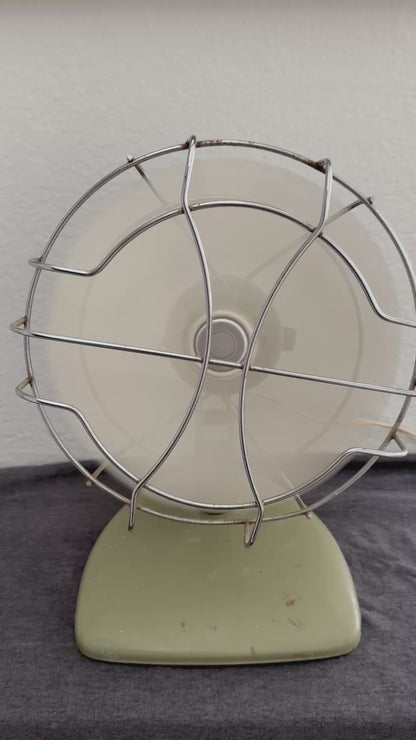 Vintage-style desk fan with white blades and metal frame against a neutral background